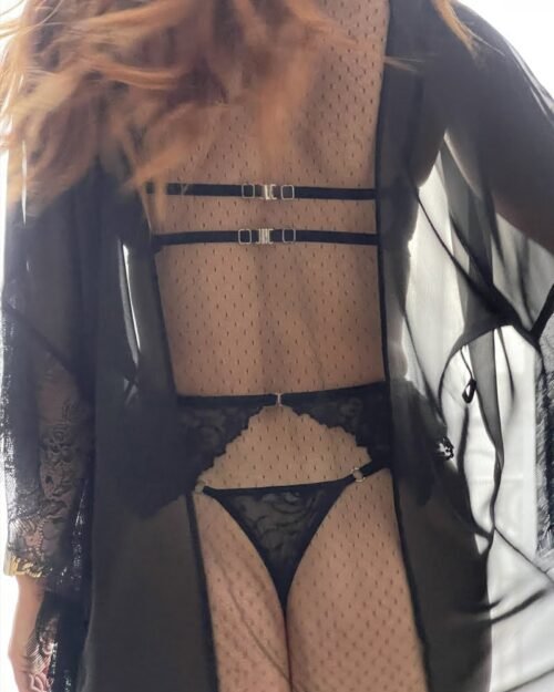 Femme de dos en ensemble lingerie coquin noir en dentelle avec porte-jarretelles.